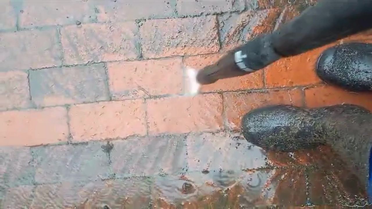 Pressure washer revealing the original red brick colour